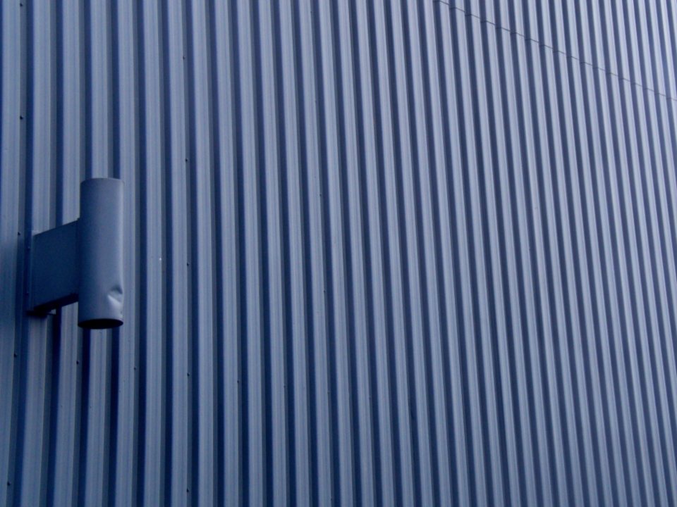 Blue ribbed surface with repeating vertical lines and shadows