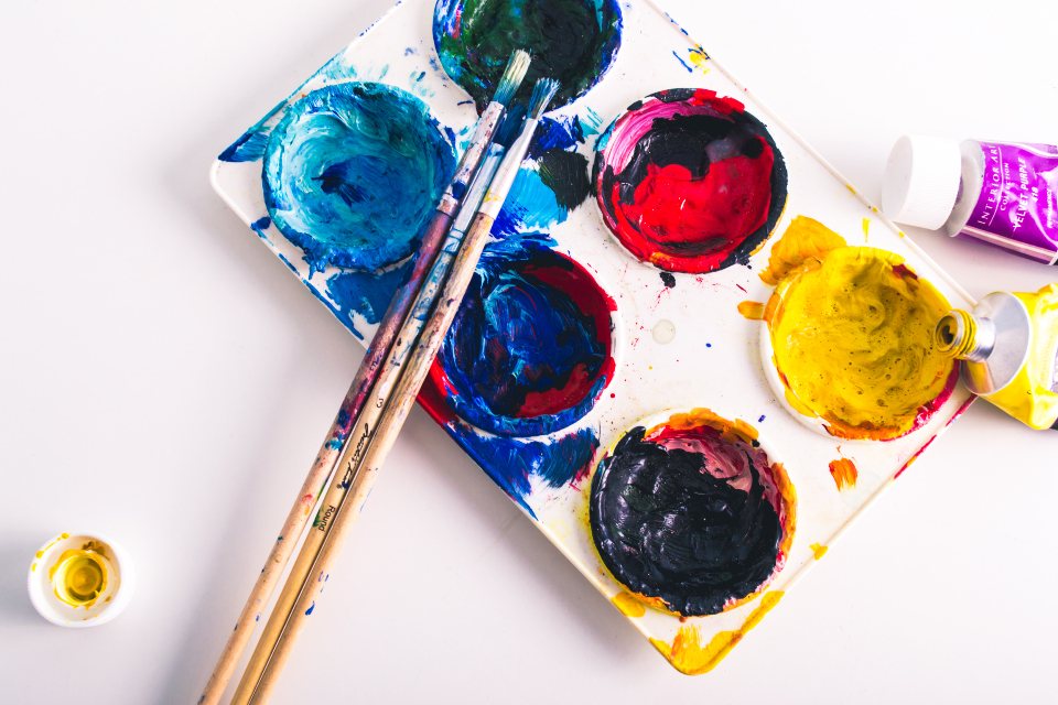 Bright blue, red and yellow paints in an artist palette