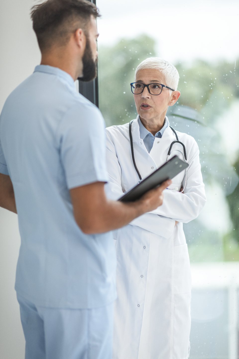 Healthcare professionals with a stethoscope and clipboard, faces out of frame