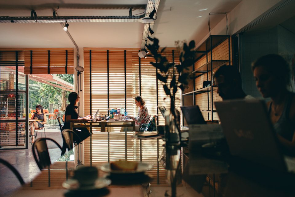 Open shared workspace with tables, plants and warm light